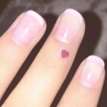 Tiny Red Heart On Finger Tattoo